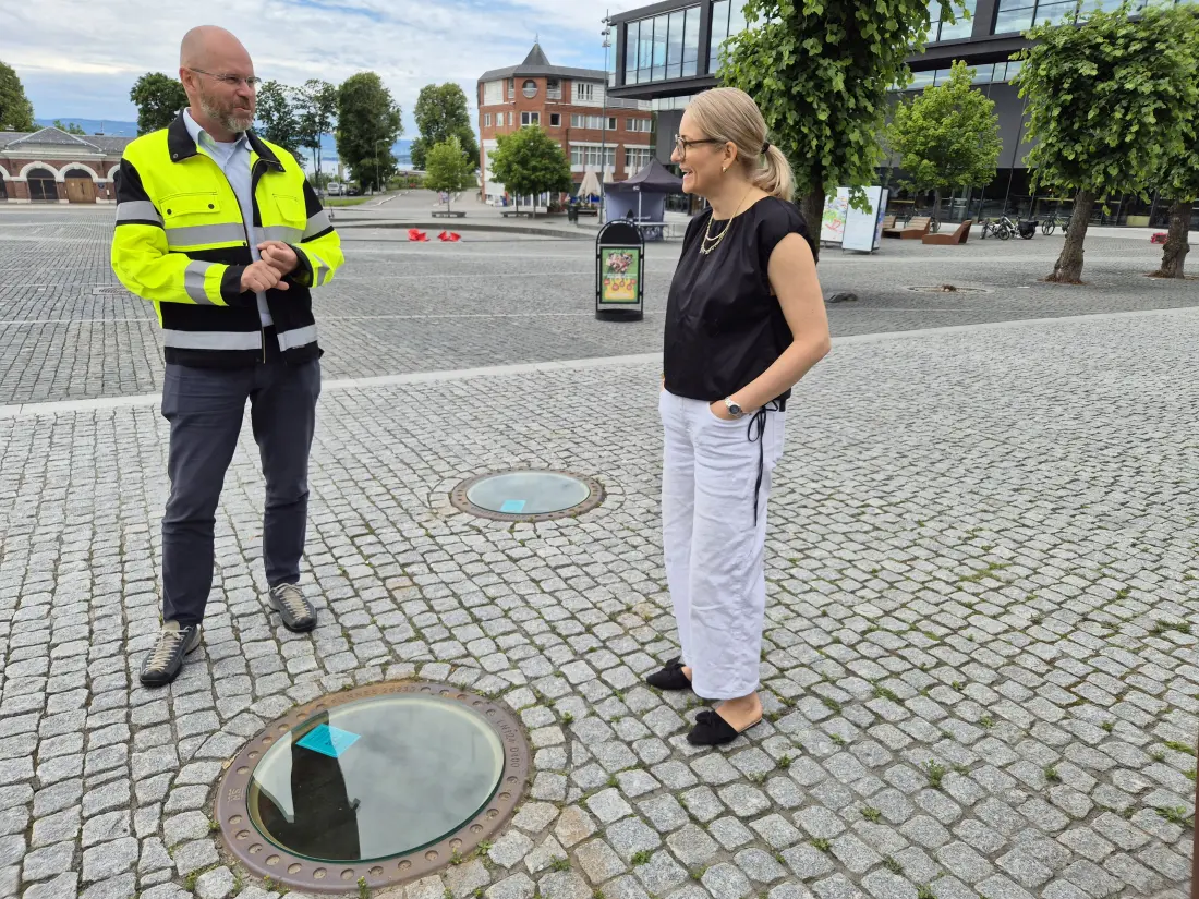 Administrerende direktør Knut Holen i Hias sammen med fungerende ordfører Jane Meyer i Hamar ved de gjennomsiktige kumlokkene på Stortorget.